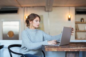 woman-using-laptop-computer-in-cafe-P4CNE4Q